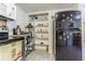 Efficient kitchen space with modern appliances, next to a shelving unit, fridge, and breakfast bar area at 4150 Woodsville Dr, New Port Richey, FL 34652
