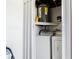 Functional laundry area includes a washer, dryer, water heater, and built-in shelving for supplies at 4150 Woodsville Dr, New Port Richey, FL 34652