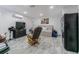 Cozy living space features a bed, tv, dresser, and a rocking chair on modern gray wood-look floors at 4150 Woodsville Dr, New Port Richey, FL 34652