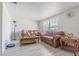 Cozy living room featuring light grey flooring, two leather couches, and large window, creating a warm space at 4150 Woodsville Dr, New Port Richey, FL 34652