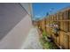 Side yard with potted plants, showcasing a well-maintained exterior with a charming fence at 4150 Woodsville Dr, New Port Richey, FL 34652