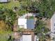 An aerial view of a charming home with mature trees, featuring a gray roof and a quaint backyard area at 417 66Th S Ave, St Petersburg, FL 33705