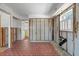 Spacious room with brick flooring and exposed walls with open doorways into other rooms of the house at 417 66Th S Ave, St Petersburg, FL 33705
