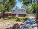 Charming home featuring a well-manicured front yard, mature trees, and a driveway, set in a serene location at 417 66Th S Ave, St Petersburg, FL 33705
