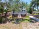 Charming two-story home with a classic brick facade, lush trees, and a private driveway, showcasing its curb appeal at 417 66Th S Ave, St Petersburg, FL 33705