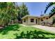 Landscaped backyard with patio, green lawn, and tropical privacy plants at 4174 14Th Ne Ln, St Petersburg, FL 33703