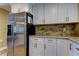 Close up of a kitchen featuring stainless steel fridge, white cabinets, and granite countertops at 4174 14Th Ne Ln, St Petersburg, FL 33703