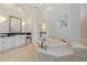 Bright primary bathroom featuring dual vanities, soaking tub, and mirrors at 4512 Cheval Blvd, Lutz, FL 33558