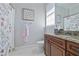 Bright bathroom features granite counters, wood cabinets, and a floral shower curtain at 4512 Cheval Blvd, Lutz, FL 33558