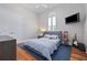 Comfortable bedroom with hardwood floors, a cozy bed, and a mounted television for relaxing at 4512 Cheval Blvd, Lutz, FL 33558