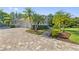 Stunning home exterior featuring lush landscaping, a paved driveway, and a three-car garage at 4512 Cheval Blvd, Lutz, FL 33558