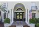 Elegant front entrance with black double doors, arched entryway, columns, and manicured landscaping at 4512 Cheval Blvd, Lutz, FL 33558