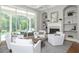 Living area features bright neutral colors, white armchairs, backyard views to the pool and fireplace at 4512 Cheval Blvd, Lutz, FL 33558