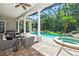 Relaxing outdoor space showcasing a screened pool, spa, stone waterfall, and comfortable patio seating at 4512 Cheval Blvd, Lutz, FL 33558