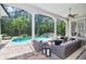 Covered patio showing pool, hot tub, and lush trees with chairs and outdoor seating at 4512 Cheval Blvd, Lutz, FL 33558