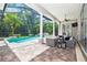 Screened pool area featuring a heated spa, luxurious wicker furniture, and a covered patio with fan at 4512 Cheval Blvd, Lutz, FL 33558