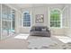 Cozy seating area in the main bedroom with backyard and pool views through bright windows at 4512 Cheval Blvd, Lutz, FL 33558