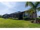 Screened-in patio with a well-manicured backyard and lush landscaping at 4888 Sevilla Shores Dr, Wimauma, FL 33598