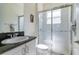 Bright bathroom showcasing a stand-up shower with glass doors and a modern white vanity at 4888 Sevilla Shores Dr, Wimauma, FL 33598