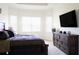 Bright bedroom featuring large windows, a television, and a wooden dresser at 4888 Sevilla Shores Dr, Wimauma, FL 33598