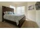 Bedroom with a dark wood bed frame, neutral carpet, and bright windows at 4888 Sevilla Shores Dr, Wimauma, FL 33598