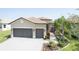 Beautiful home exterior with a tile roof, paver driveway, two car garage, and professional landscaping at 4888 Sevilla Shores Dr, Wimauma, FL 33598