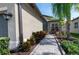 Side exterior of home showing the paver walkway and tropical landscaping leading to the front door at 4888 Sevilla Shores Dr, Wimauma, FL 33598