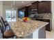 Spacious kitchen featuring a large island, granite countertops, and stainless steel appliances at 4888 Sevilla Shores Dr, Wimauma, FL 33598
