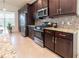 Well-equipped kitchen with stainless steel appliances, granite countertops, and dark cabinetry at 4888 Sevilla Shores Dr, Wimauma, FL 33598