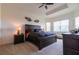 Primary bedroom featuring tray ceilings, carpet floors, ceiling fan, and bright windows at 4888 Sevilla Shores Dr, Wimauma, FL 33598