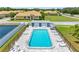 Aerial view of a pool surrounded by landscaping, featuring lounge chairs and community homes at 4943 New England Blvd # 105, New Port Richey, FL 34652