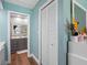 Hallway view leading to bathroom vanity, featuring bi-fold closet doors at 4943 New England Blvd # 105, New Port Richey, FL 34652