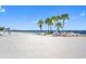 Expansive beach view with palm trees, and clear blue skies perfect for relaxing by the sea at 4943 New England Blvd # 105, New Port Richey, FL 34652