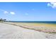 Panoramic beach view with sandy shoreline and clear blue skies, ideal for a tranquil coastal getaway at 4943 New England Blvd # 105, New Port Richey, FL 34652