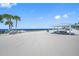 Expansive sandy beach featuring clear blue skies, calm ocean waters, and shaded picnic structures at 4943 New England Blvd # 105, New Port Richey, FL 34652