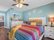 Bright bedroom with colorful bedding, wooden floors and a ceiling fan at 4943 New England Blvd # 105, New Port Richey, FL 34652