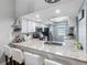 Modern kitchen bar with granite countertop, open layout, and ample natural light at 4943 New England Blvd # 105, New Port Richey, FL 34652