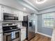 Bright kitchen with stainless steel appliances, ample cabinet space, and modern finishes at 4943 New England Blvd # 105, New Port Richey, FL 34652