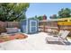 Backyard features a blue storage shed, hot tub, and seating area for outdoor relaxation and storage at 513 W Paris St, Tampa, FL 33604