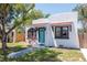 Charming home featuring white stucco, a red tile awning, an arch window and a striking turquoise door at 513 W Paris St, Tampa, FL 33604
