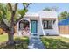 Charming home featuring white stucco, a red tile awning, an arch window and a striking turquoise door at 513 W Paris St, Tampa, FL 33604