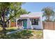 Charming home featuring white stucco, a red tile awning, an arch window and a striking turquoise door at 513 W Paris St, Tampa, FL 33604