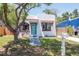 Charming home featuring white stucco, a red tile awning, an arch window and a striking turquoise door at 513 W Paris St, Tampa, FL 33604