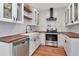 Modern kitchen featuring white cabinets, wood countertops, stainless steel appliances, and white subway tile backsplash at 513 W Paris St, Tampa, FL 33604