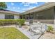 View of the backyard with lanai, grill, seating, and manicured hedges at 5434 Wellfield Rd, New Port Richey, FL 34655
