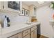 Close-up of the bar featuring a clean countertop, custom cabinets, and a built-in mini fridge at 5434 Wellfield Rd, New Port Richey, FL 34655