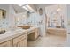 Elegant bathroom featuring double sinks, custom cabinetry, and a luxurious soaking tub with stained glass art at 5434 Wellfield Rd, New Port Richey, FL 34655