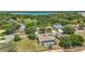 Aerial view of a home with a screened-in pool, surrounded by lush greenery and a lake in the distance at 5465 Chestnut Ridge Rd, Dade City, FL 33523