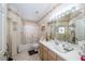 Bright bathroom features light wood cabinets, a large mirror, tile flooring, and a tub/shower combo at 5465 Chestnut Ridge Rd, Dade City, FL 33523