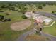 Aerial view of the expansive clubhouse set amongst lush greenery, with ample parking for members and guests at 5465 Chestnut Ridge Rd, Dade City, FL 33523